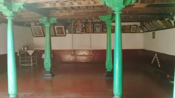 A room in the headman's house with four green pillars